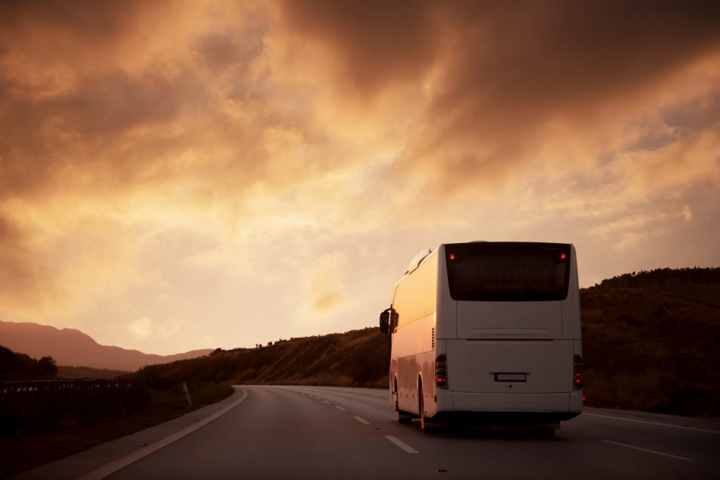 Ônibus da Mobile Turismo em viagem ao entardecer